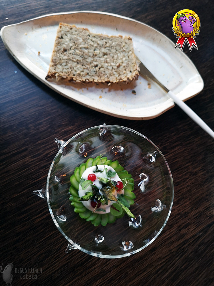 Top photo of the same salad bowl. Next to a white plate with a slice of bread with sunflower seeds.