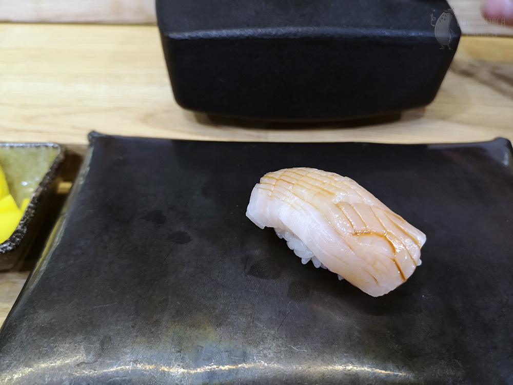 Nigiri with light fish topped with sauce.