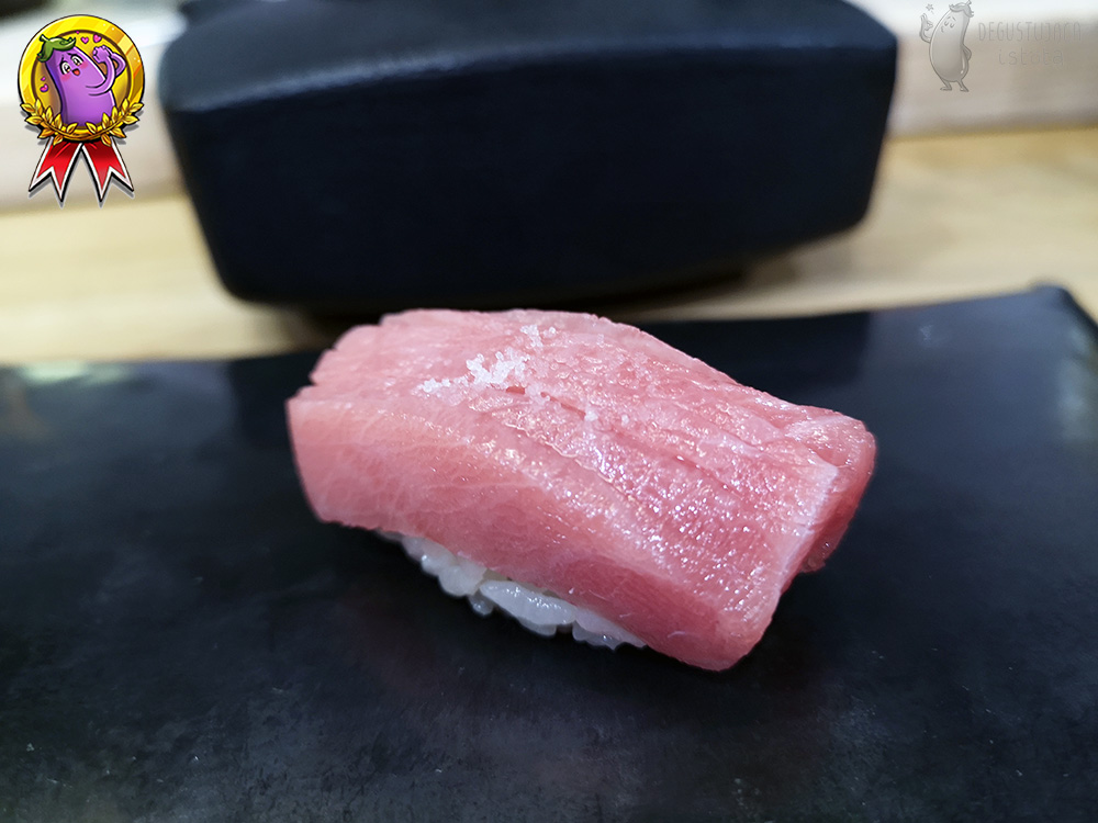 Nigiri z jasną, marmurkowatą częścią tuńczyka z odrobiną soli na wierzchu.
