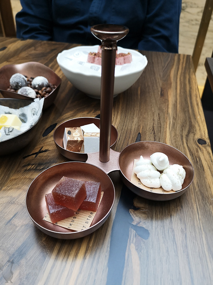 Copper three bowls joined together. In them separately: nougat with nuts, meringue and jelly beans in sugar.