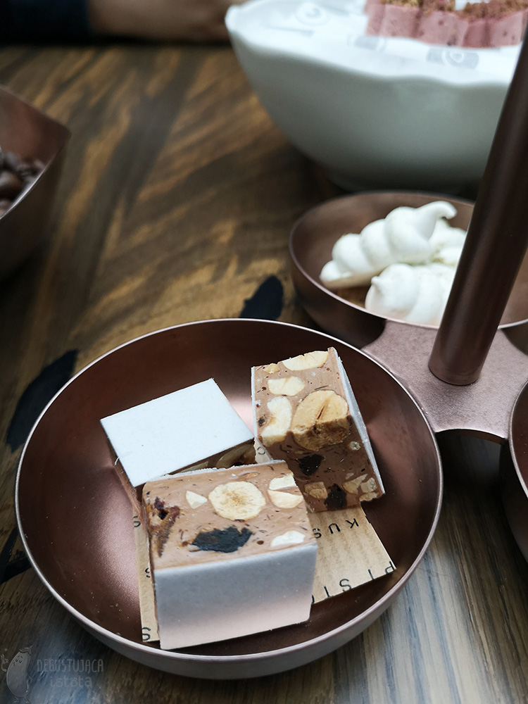 There are three pieces of nougat in a copper bowl.
