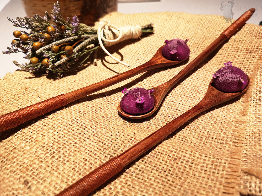 On wooden spoons, There are purple balls, crushed with purple powder and decorated with small purple flowers.
