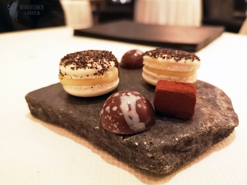  Two pieces of stone are placed on the stone: bright macarons, semicircular pralines, cube-shaped chocolate truffles and macaroons.