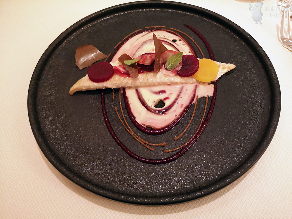  On the black plate lies a strip of fish around which, with different sauces, circles are painted. On a Sole fish are round slices of beets of different color. The center is additionally poured with a white lemon sauce.